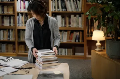 Quiet Librarian Organizing Books in Reading Room