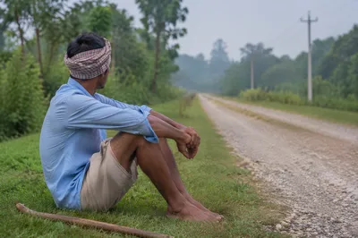 Reflective Man Resting Beside Rural Road