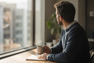 Thoughtful Professional Man by Office Window