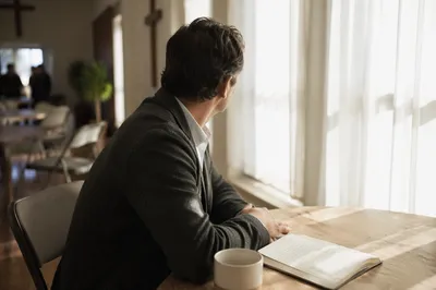 Thoughtful Professional Man in Sunlit Community Room