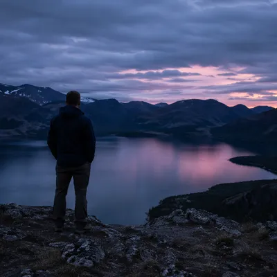 Solitary Man Overlooking Mountain Lake at Dusk
