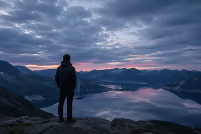 Solitary Man Overlooking Twilight Mountain Lake