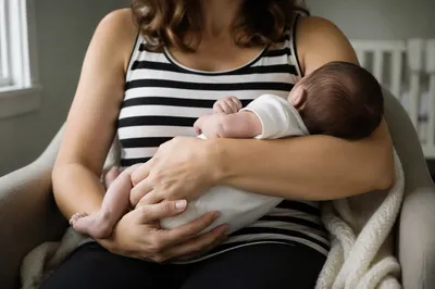 Tender Mother Cradling Newborn at Home
