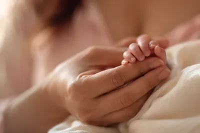 Tender Mother and Newborn Hand Bond