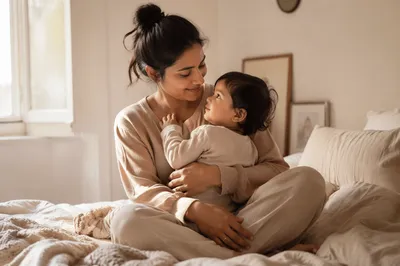 South Asian Mother Holding Toddler on Bed