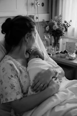 Mother Holding Newborn in Hospital Bed