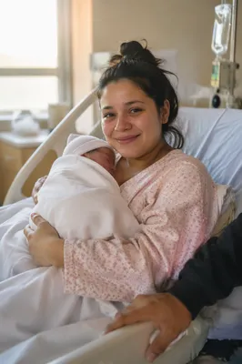 Mother Holding Newborn in Hospital Room