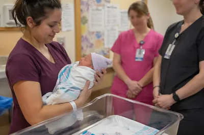 Mother Holding Newborn in Hospital Room