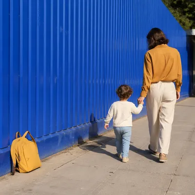 Parent and Child Walking by Blue Wall