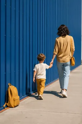 Parent and Child Walking by Blue Wall