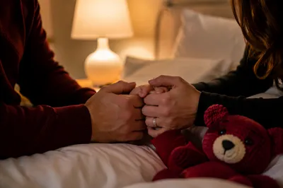 Parents Praying Over Child at Bedtime