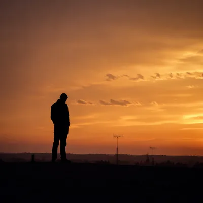 Contemplative Silhouette Under Dramatic Sunset