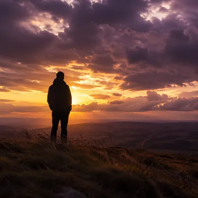 Silhouetted Figure Praying at Dramatic Sunset