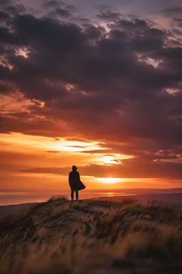 Lone Silhouette on Hill at Sunset