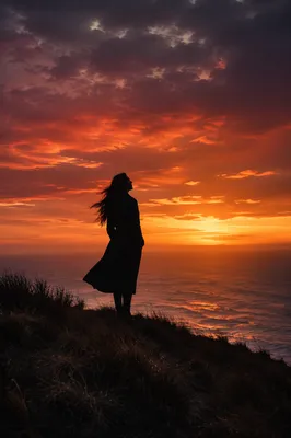 Woman Silhouette on Coastal Bluff at Sunset