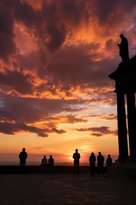 Prayerful Silhouettes Beneath Dramatic Sunset Clouds