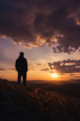 Lone Silhouette Beneath Dramatic Sunset Sky