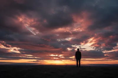 Solitary Silhouette Under Dramatic Sunset Sky