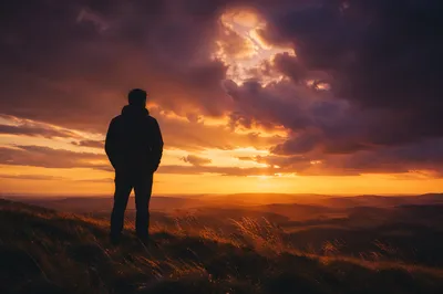 Silhouetted Figure Praying at Dramatic Sunset