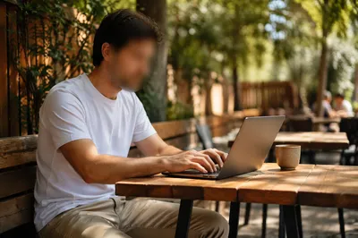 Focused Laptop Work at Outdoor Cafe