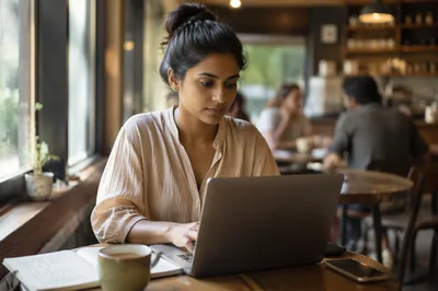 Focused Woman Working on Laptop in Cafe