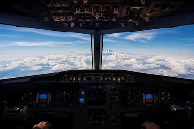 Pilot Hands in Airplane Cockpit Above Clouds