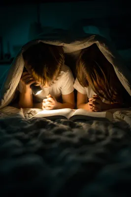 Siblings Praying Under Blanket Fort at Bedtime