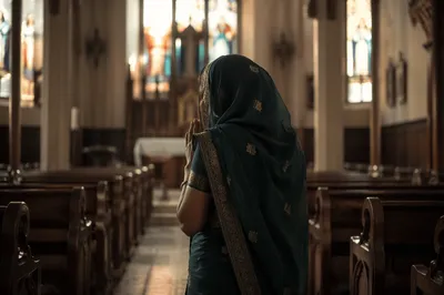 South Asian Woman Praying in Church Aisle
