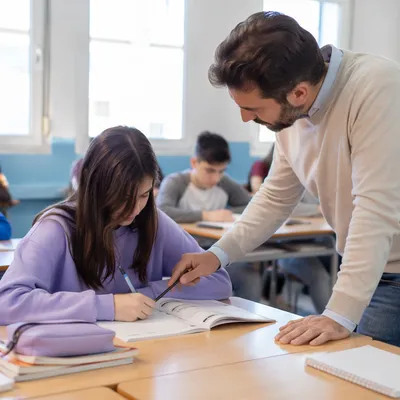 Teacher Guiding Student in Bright Classroom
