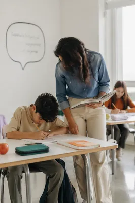 Diverse Teacher Supporting Students in Classroom