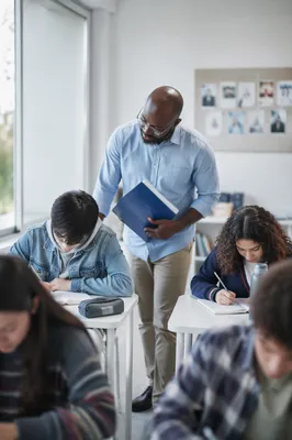 Diverse Teacher Supporting Students in Classroom