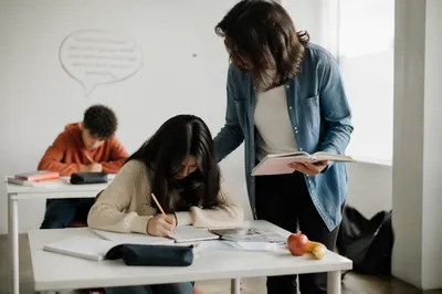 Diverse Teacher Helping Students in Classroom