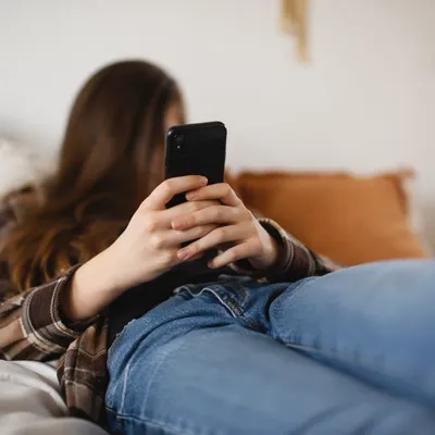 Teen Student Relaxing with Phone at Home
