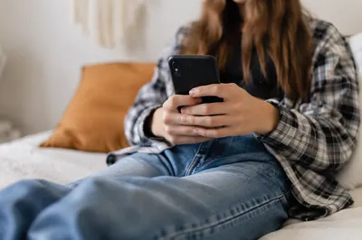 Teen Student Relaxing with Smartphone Indoors
