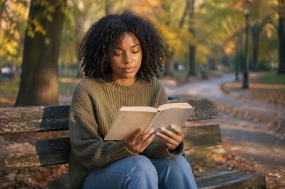 Young Woman Reading on Park Bench