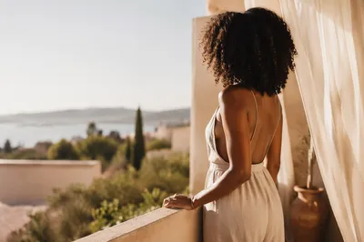 Confident Woman on Sunlit Balcony Portrait