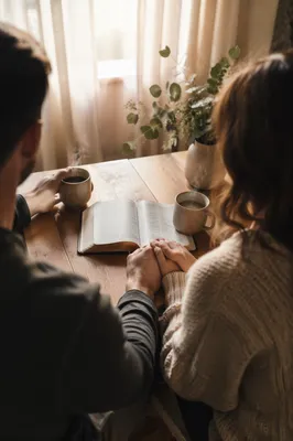 Young Couple Reading Bible Over Coffee