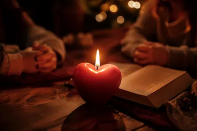 Heart Shaped Candle Beside Open Book