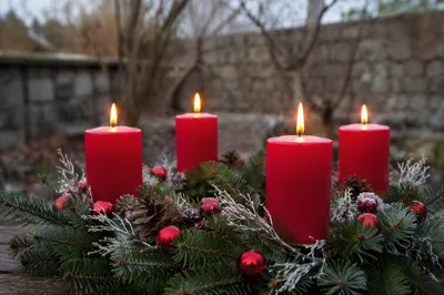 Four Lit Advent Candles in Evergreen Wreath