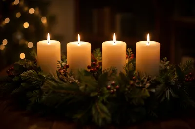 Four Lit Advent Candles on Evergreen Wreath