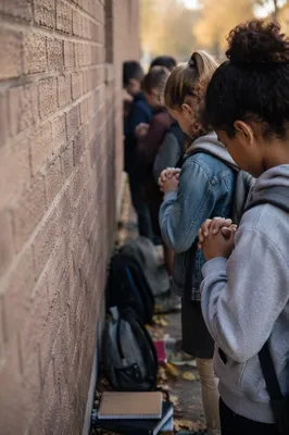 Children Praying at School Wall in Autumn