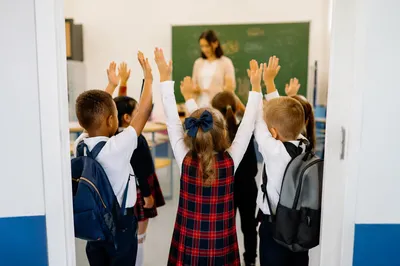 Children Praying in Bright School Classroom
