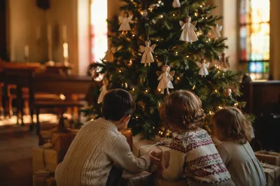 Children Placing Gifts by Christmas Angel Tree