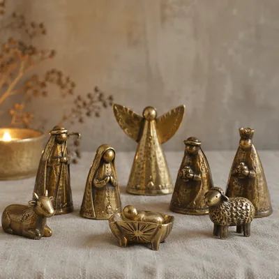 Candlelit Metal Nativity on Gray Fabric
