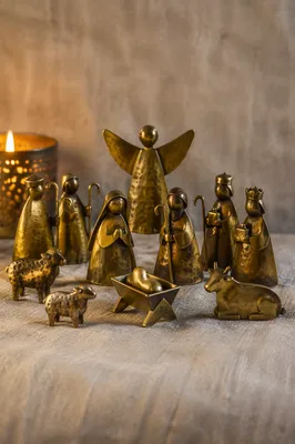 Candlelit Metal Nativity on Gray Fabric