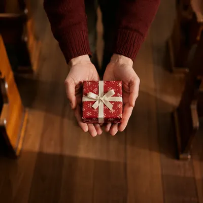 Hands Offering Christmas Gift in Church