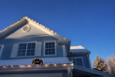 Hanging Christmas Lights on Suburban Rooftop
