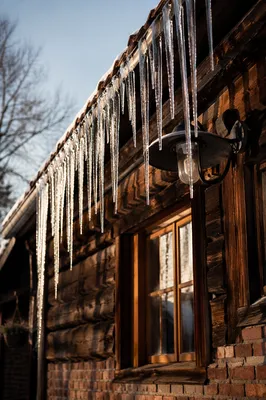 Sunlit Icicles on Rustic Winter Eaves
