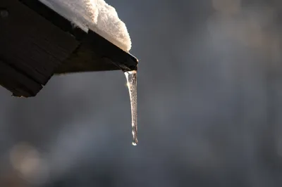 Winter Sunlit Icicle on Roof Eave