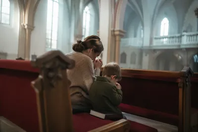 Mother and Child Praying in Winter Sanctuary
